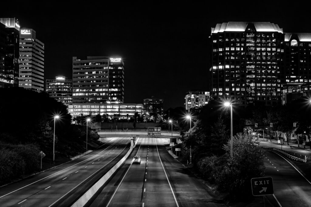 a black and white photo of a highway leading to Richmond, VA with buildings in the background